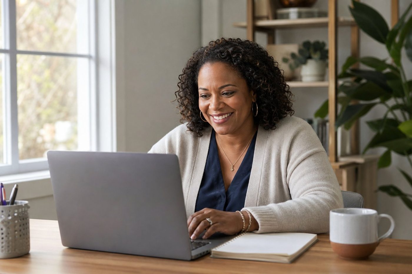 Woman smiling while taking an online course on her laptop at home